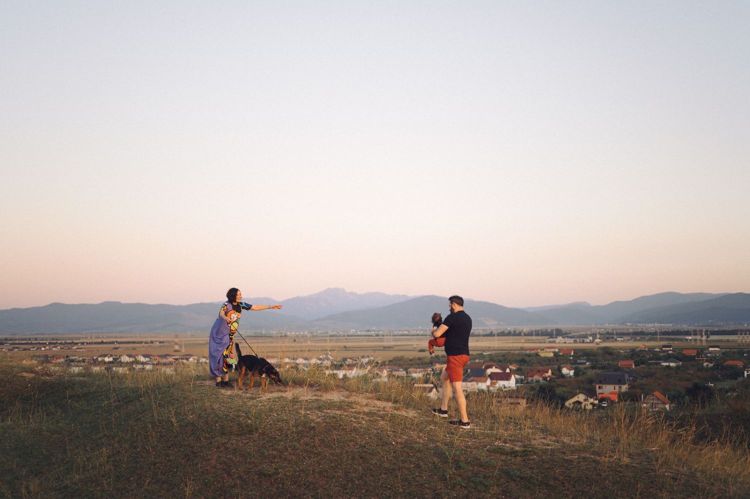 A panoramic series of landscape shots showing people silhouetted on a hilltop overlooking mountains and distant terrain.