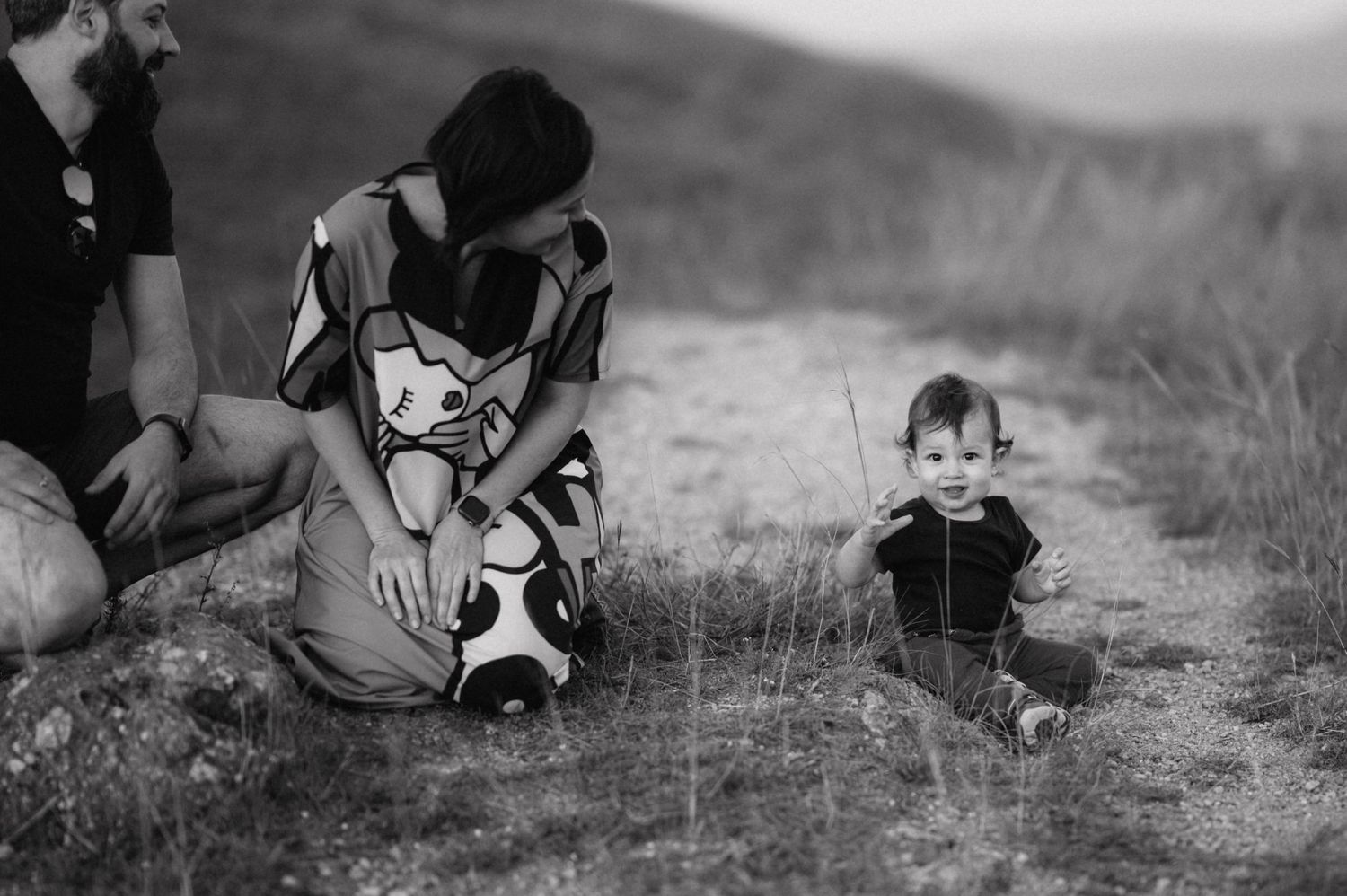 Black and white photo series showing someone playing with a dog in a grassy field during a summer afternoon.