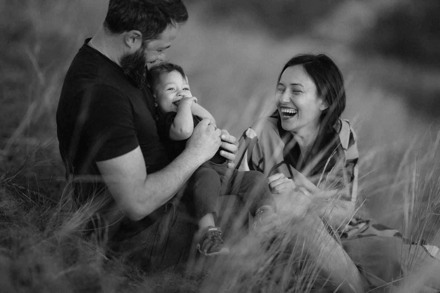 A series of intimate black and white photographs showing a couple sharing joyful, candid moments together outdoors.