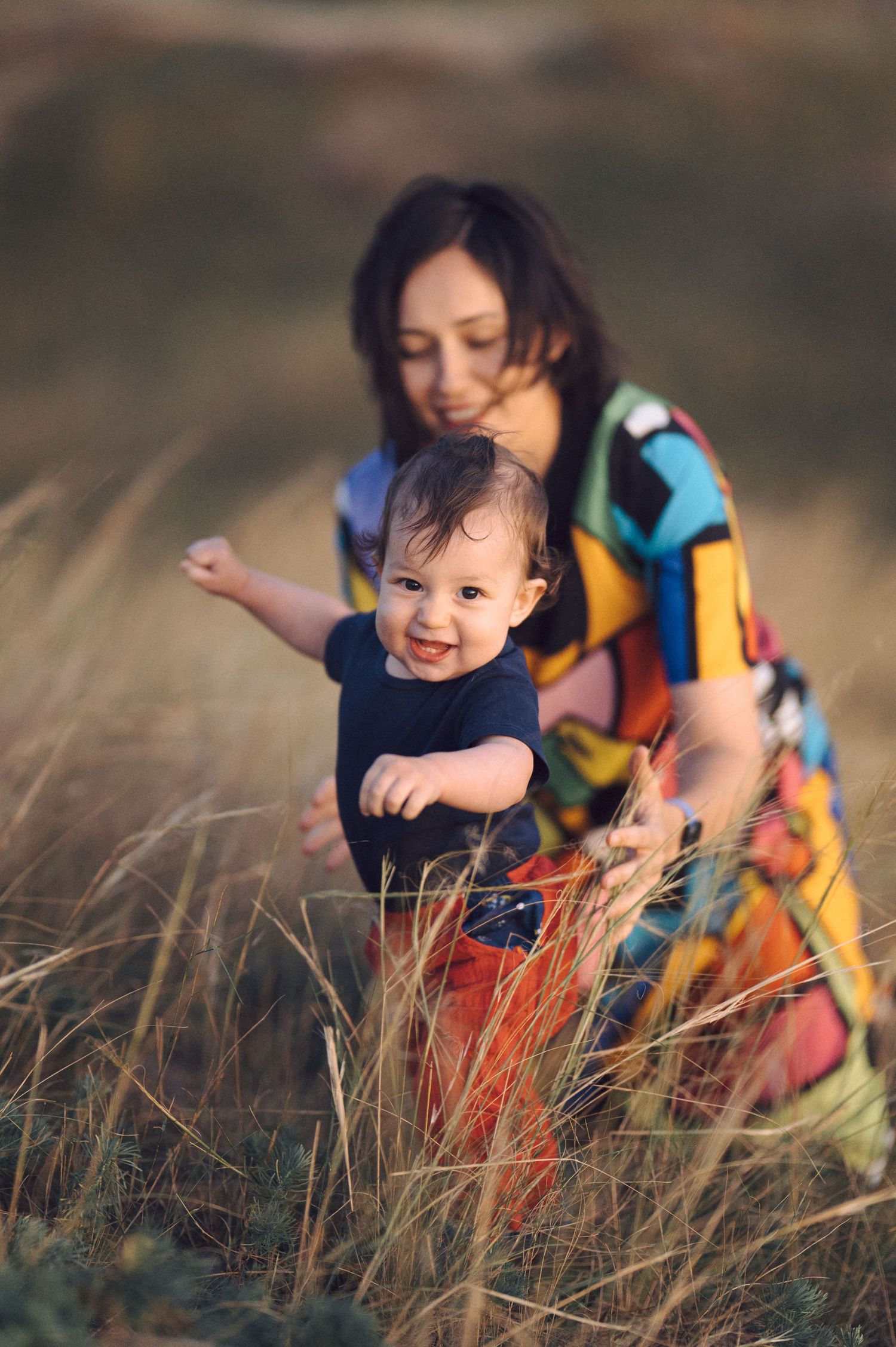 A joyful moment shared among tall grass during sunset.