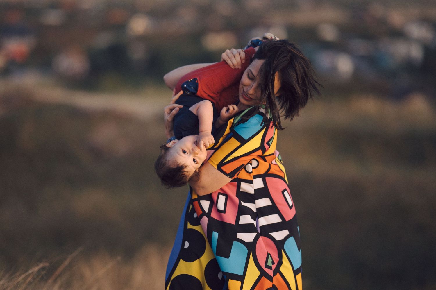An energetic playtime moment in a colorful patterned dress outdoors.