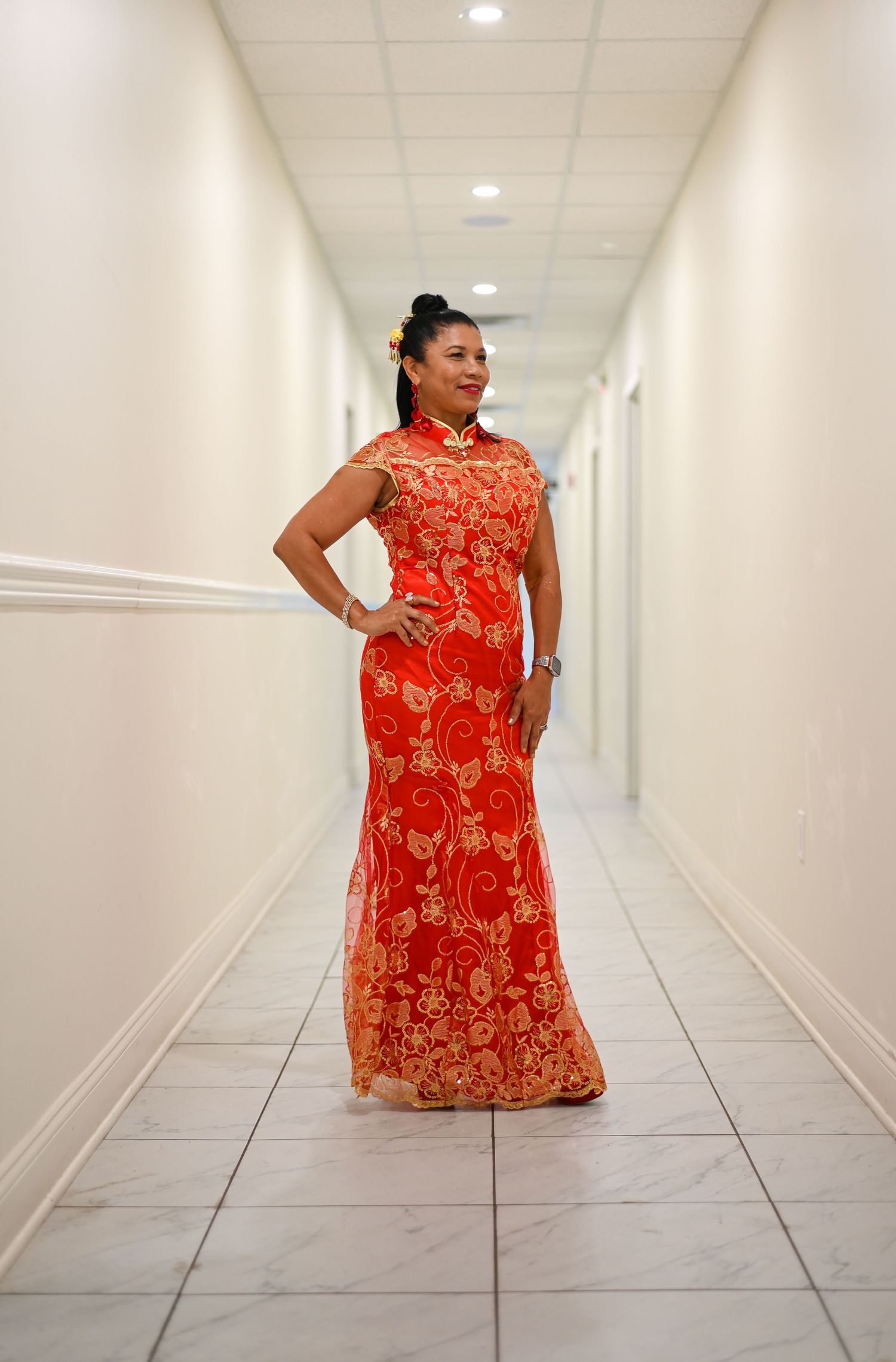 A stunning red and gold traditional dress photographed in a white hallway.