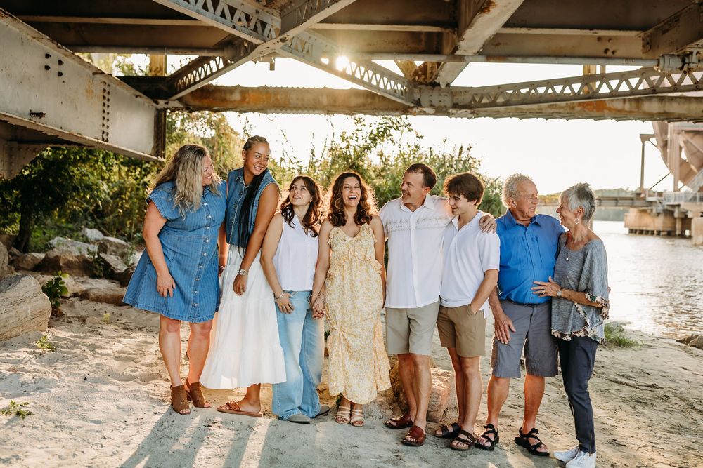 Family members pose for group photos at sunset on a tropical beach in casual summer attire with palm trees in background.