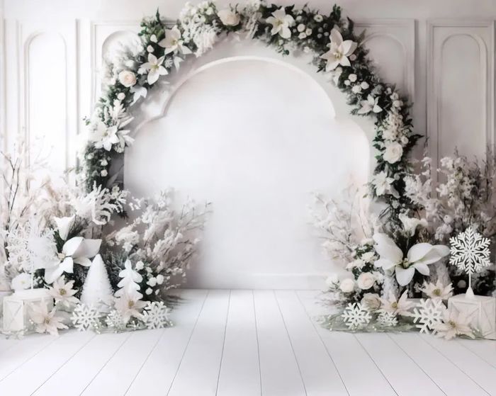 Holiday photo backdrop with white curtains, white and green floral garland, and decorative snowflakes on the wall.