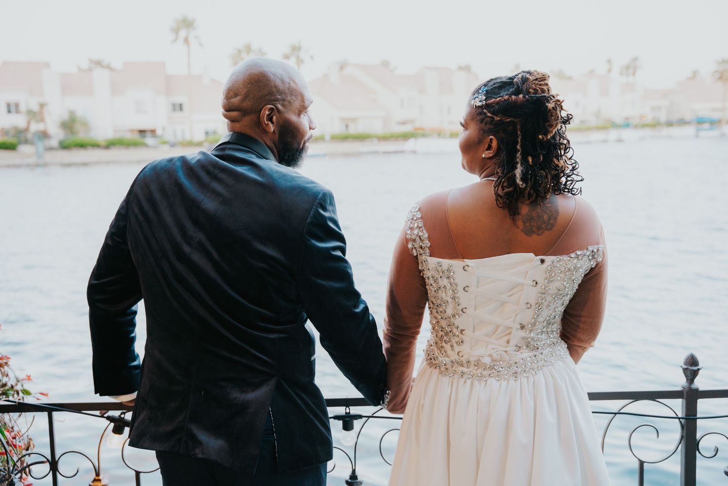 Black and white photo grid showing wedding couple moments in formal attire on a lakeside railing.