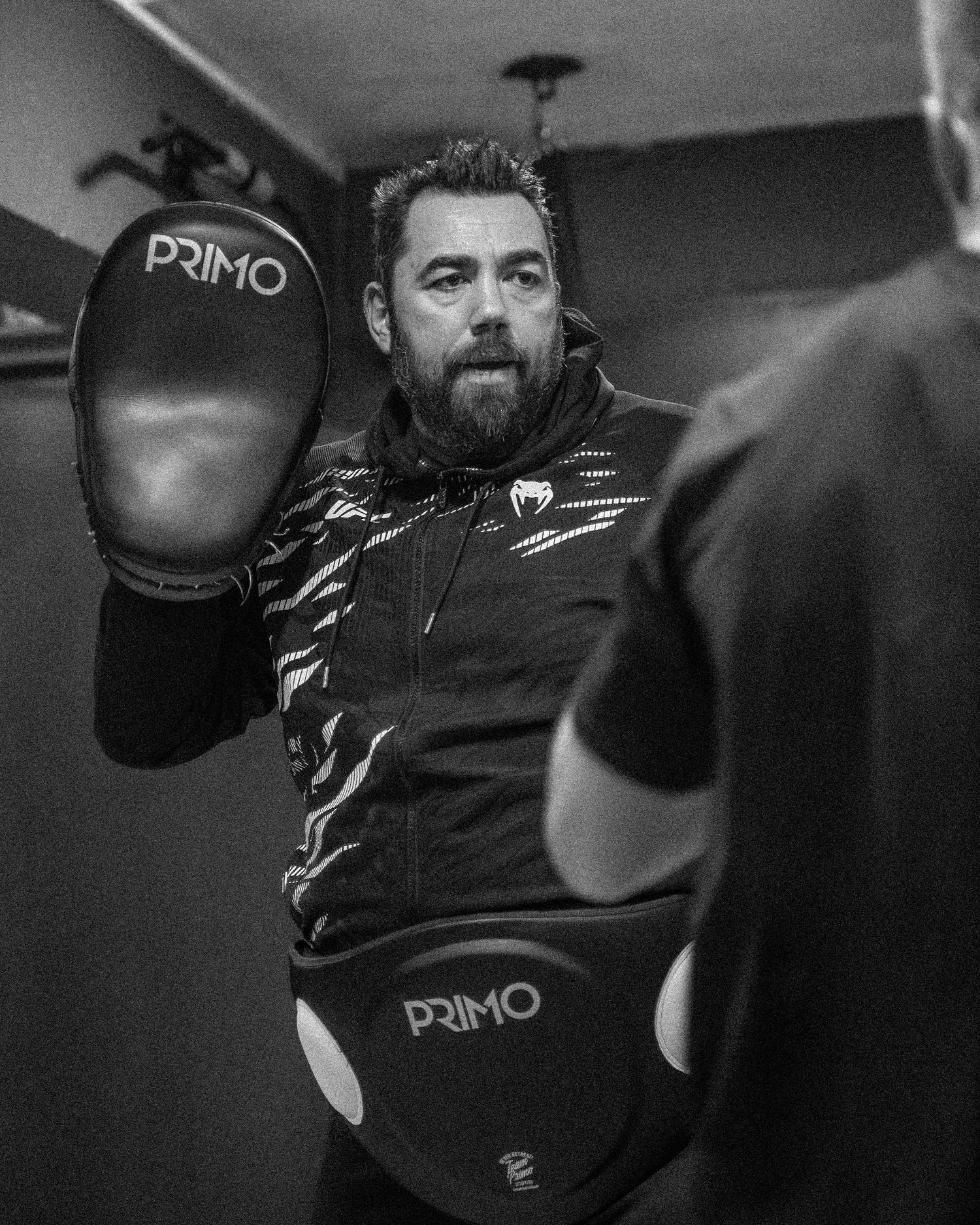 Boxers training in a professional fitness academy with a boxing ring and equipment.