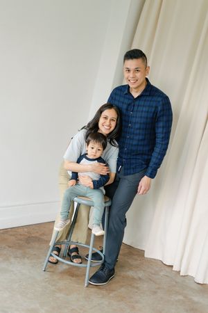A series of family portrait shots in an indoor studio space with light curtains and minimalist decor.