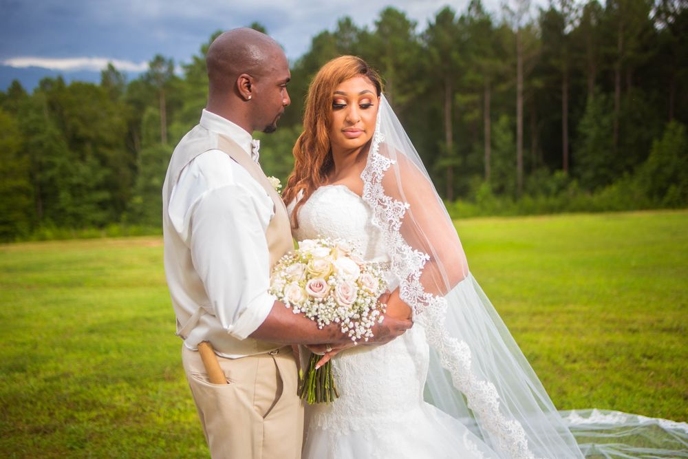Wedding couple shares intimate moments in a scenic outdoor setting with green fields.