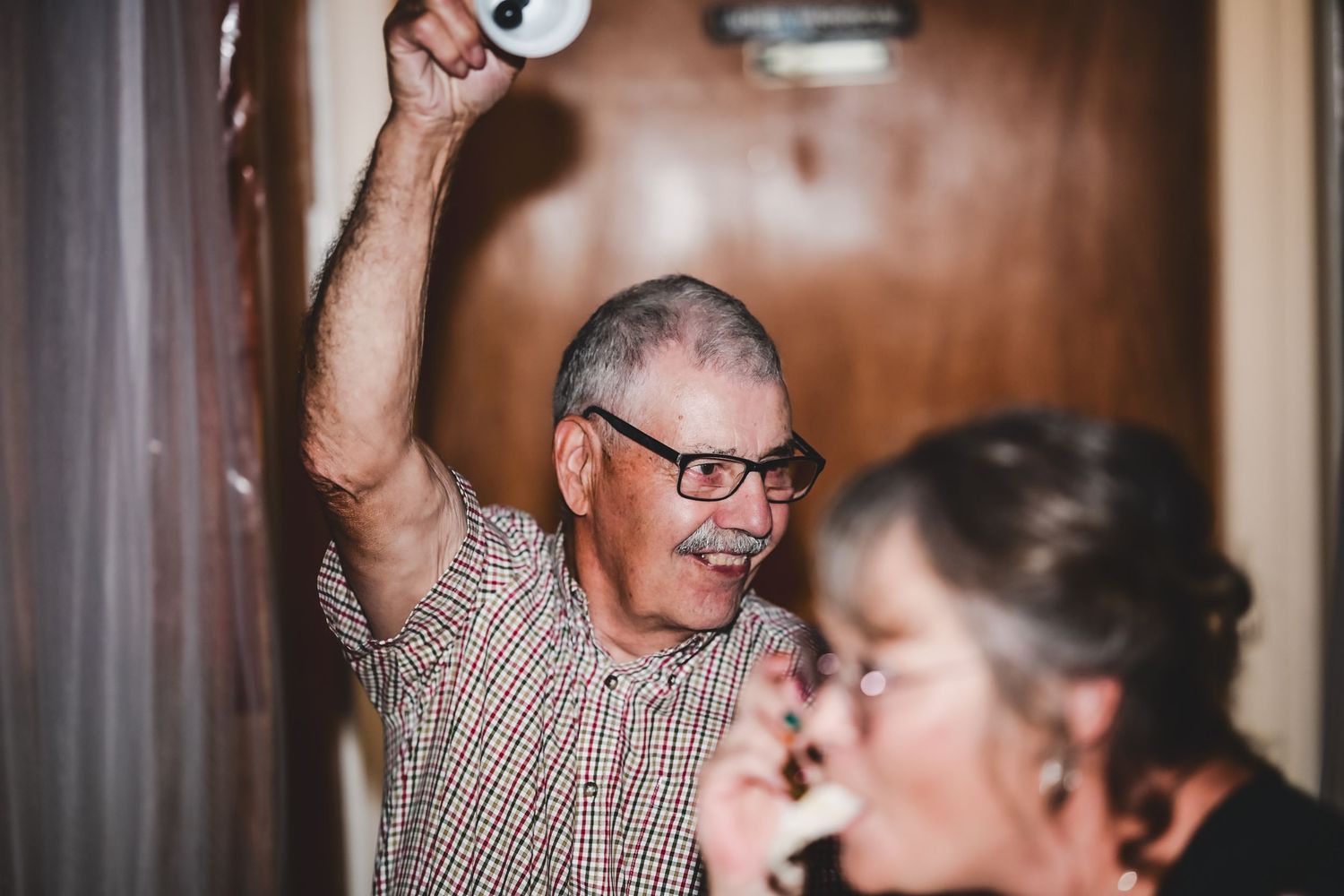 Guest celebrating at a wedding reception, arms raised and laughing, Newfoundland.
