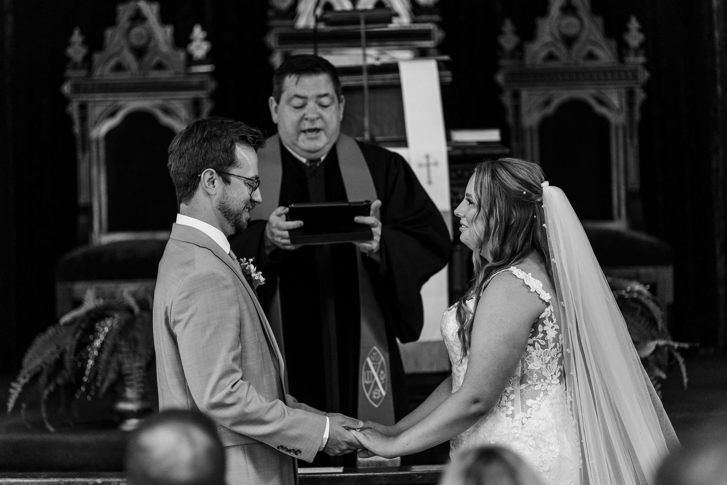 A romantic black and white photo series showing intimate moments between a bride and groom during their church wedding ceremony.