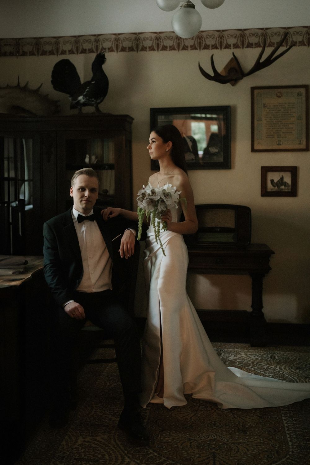 Intimate wedding photography session in a dimly lit room with vintage decor and moody atmosphere.