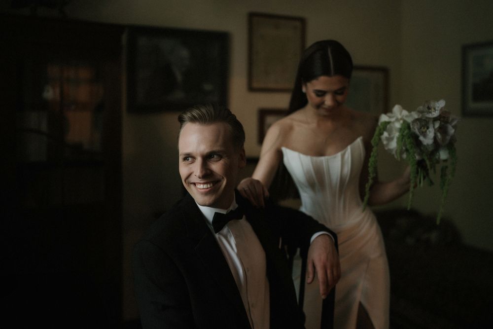 Artistic wedding portraits captured in dramatic shadows against dark interior walls.