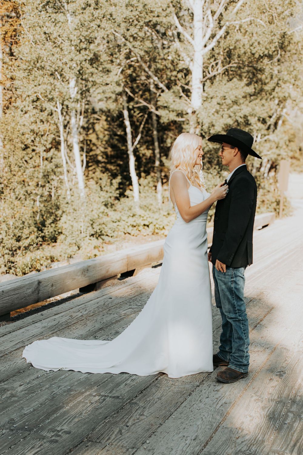 A rustic country wedding sequence showing a couple in western attire dancing together on a wooden platform.
