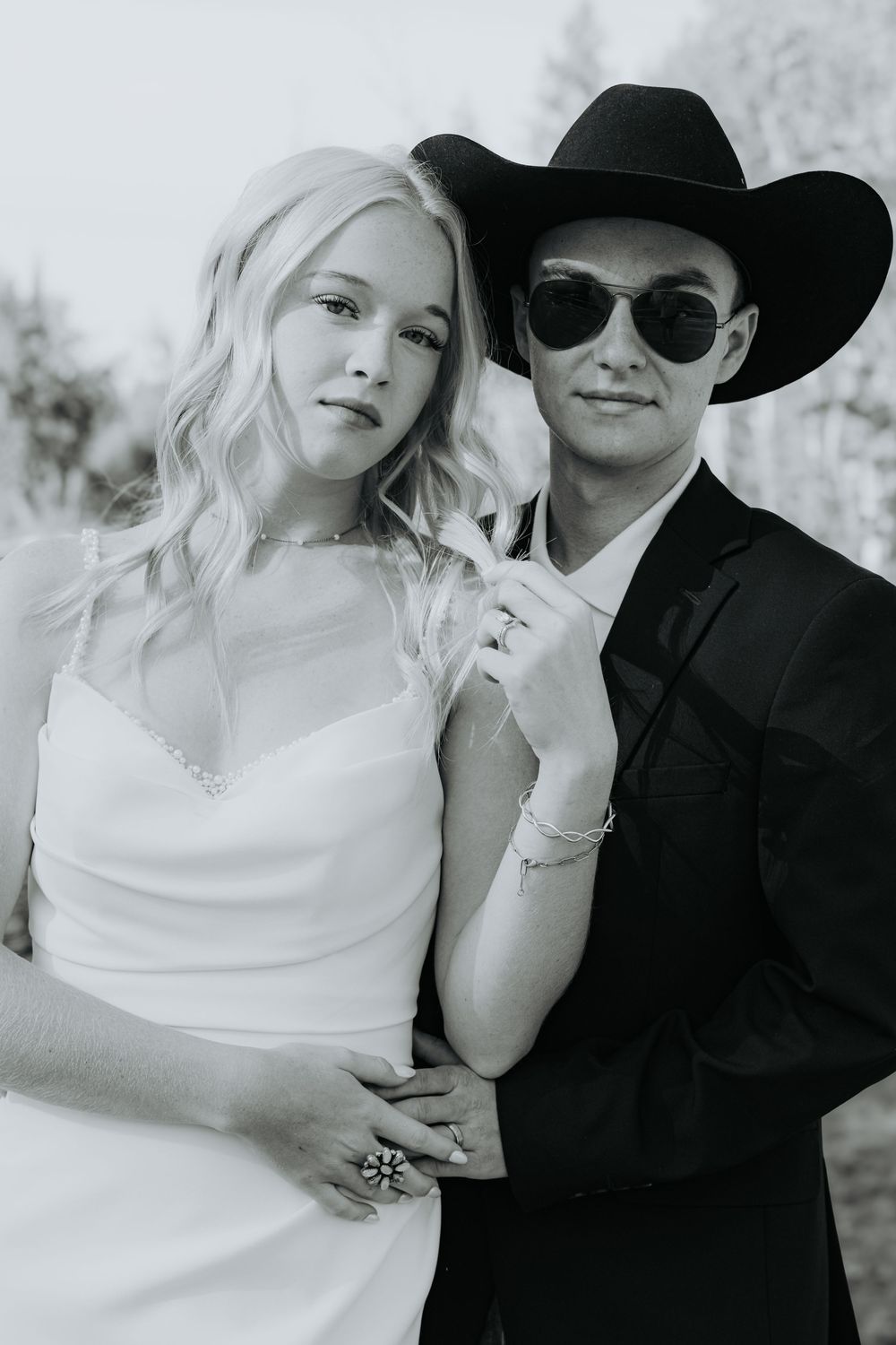 A romantic black and white photo series showing a couple in wedding attire posing intimately against a light background.