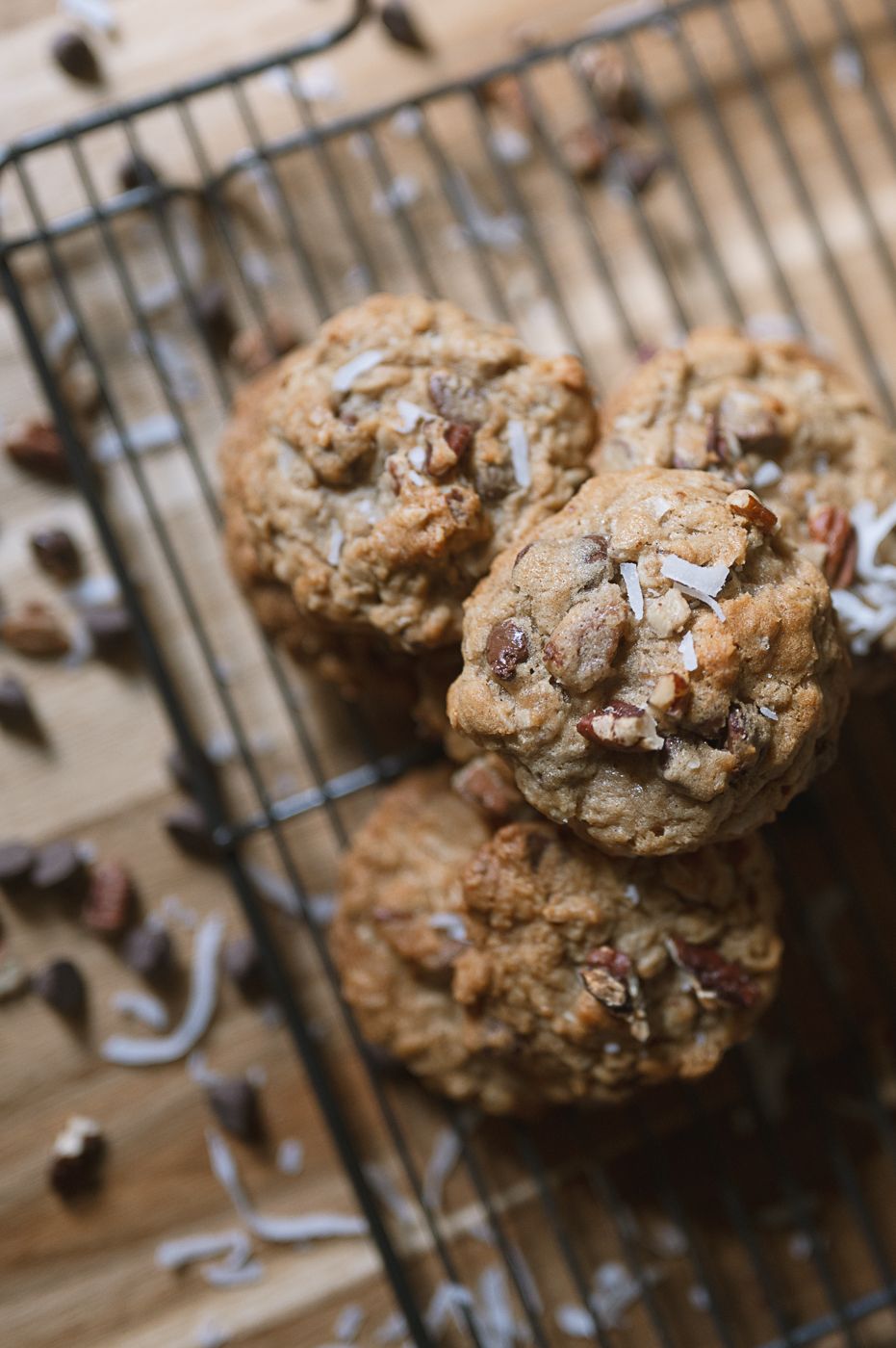 Close-up view of homemade chocolate chip cookies studded with coconut on a cooling rack.