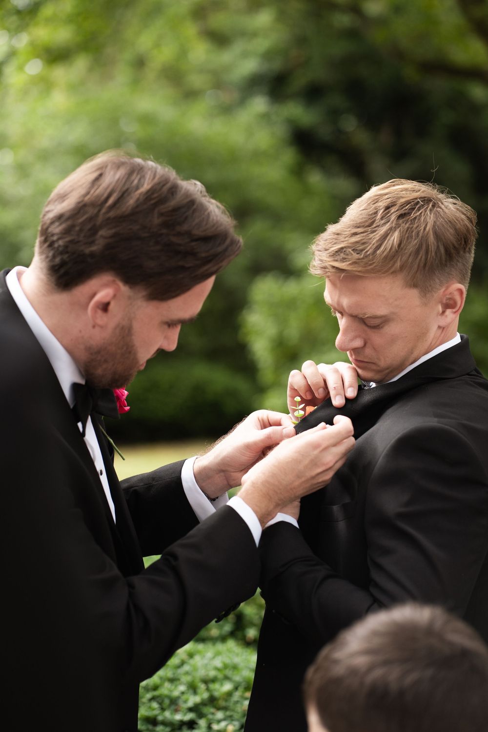 A sequence of five photos showing two men in black tuxedos sharing an emotional moment outdoors.