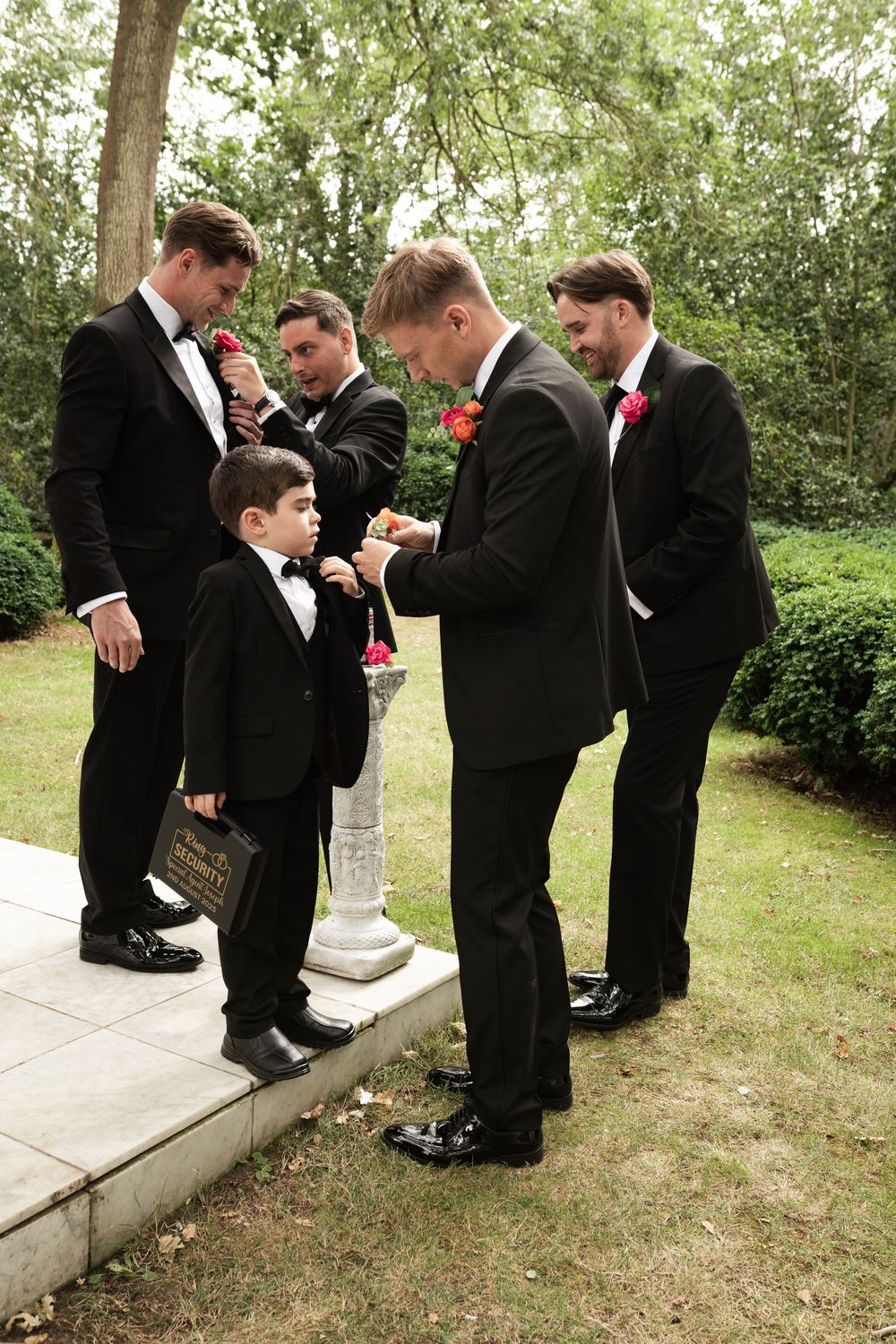 A set of photos showing groomsmen drinking from flasks while standing in formal tuxedos outdoors.