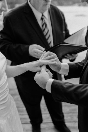 Close-up of hands exchanging rings during a wedding ceremony.