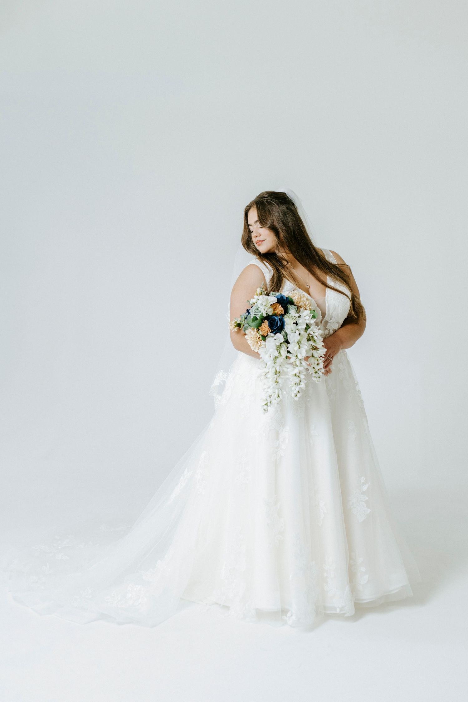 A flowing white bridal gown with delicate lace details is captured in an elegant photoshoot from multiple angles.