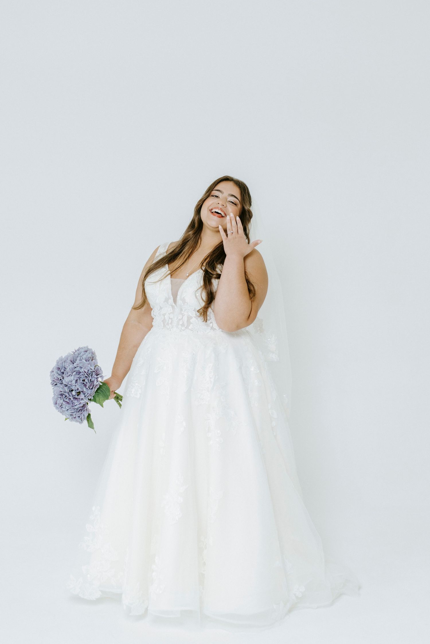 Joyful movement series in white lace dress against minimal light grey backdrop with floral accents.