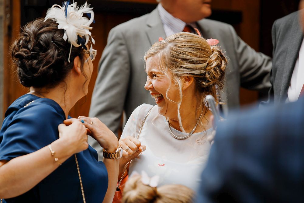 A joyful wedding moment captured in black and white as couples dance together at a celebration reception.