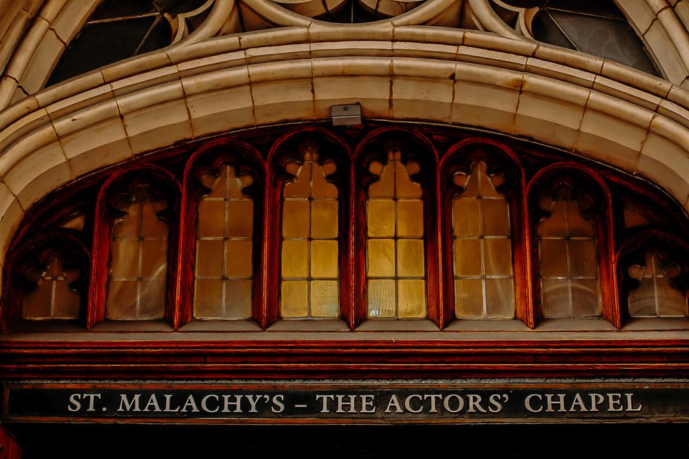 Gothic arched entrance to St. Malachy's Actors' Chapel featuring ornate architectural details and stained glass windows.