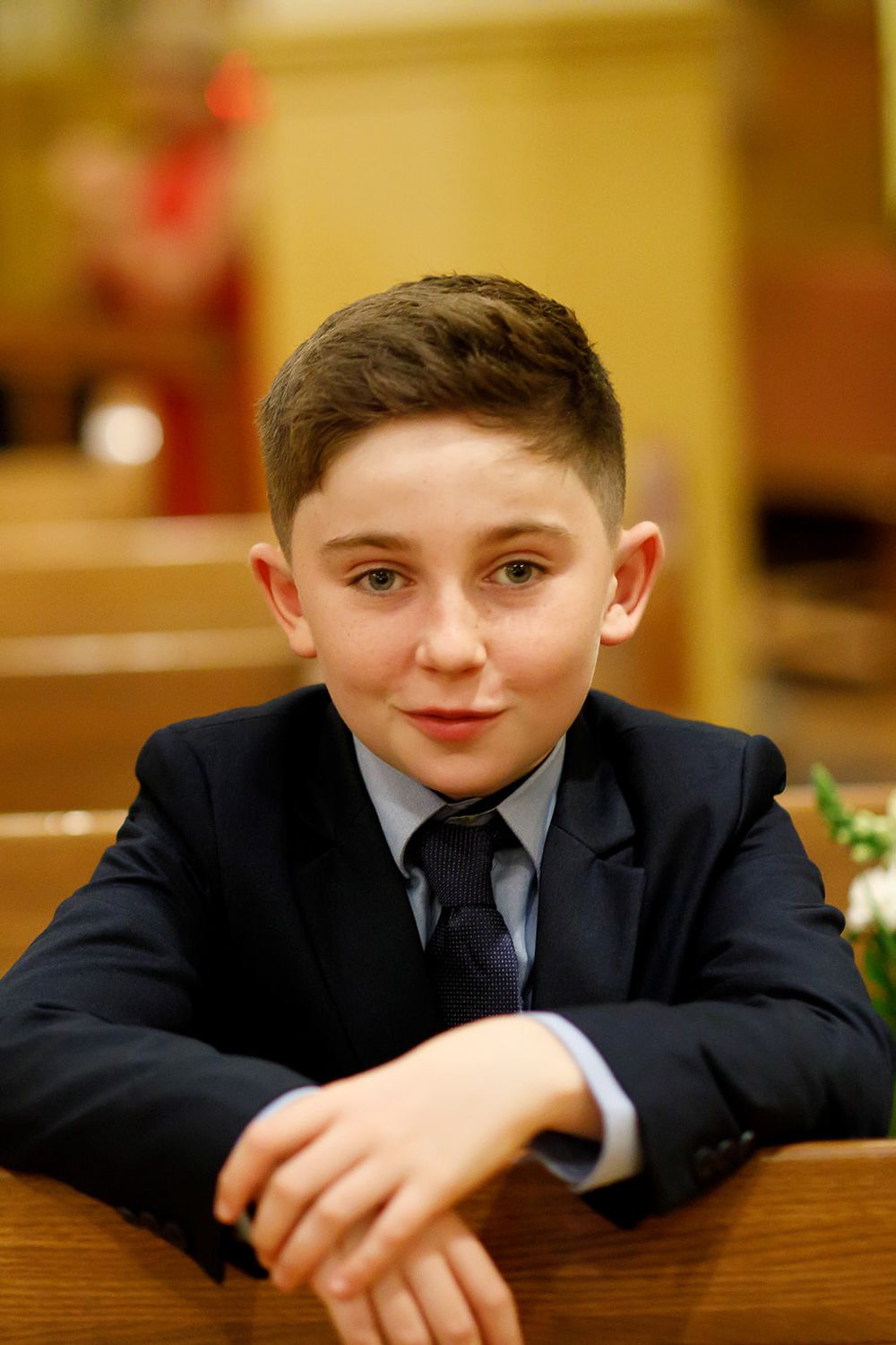 Five sequential images show a child in a dark suit resting their head and arms on a wooden surface with varying expressions.