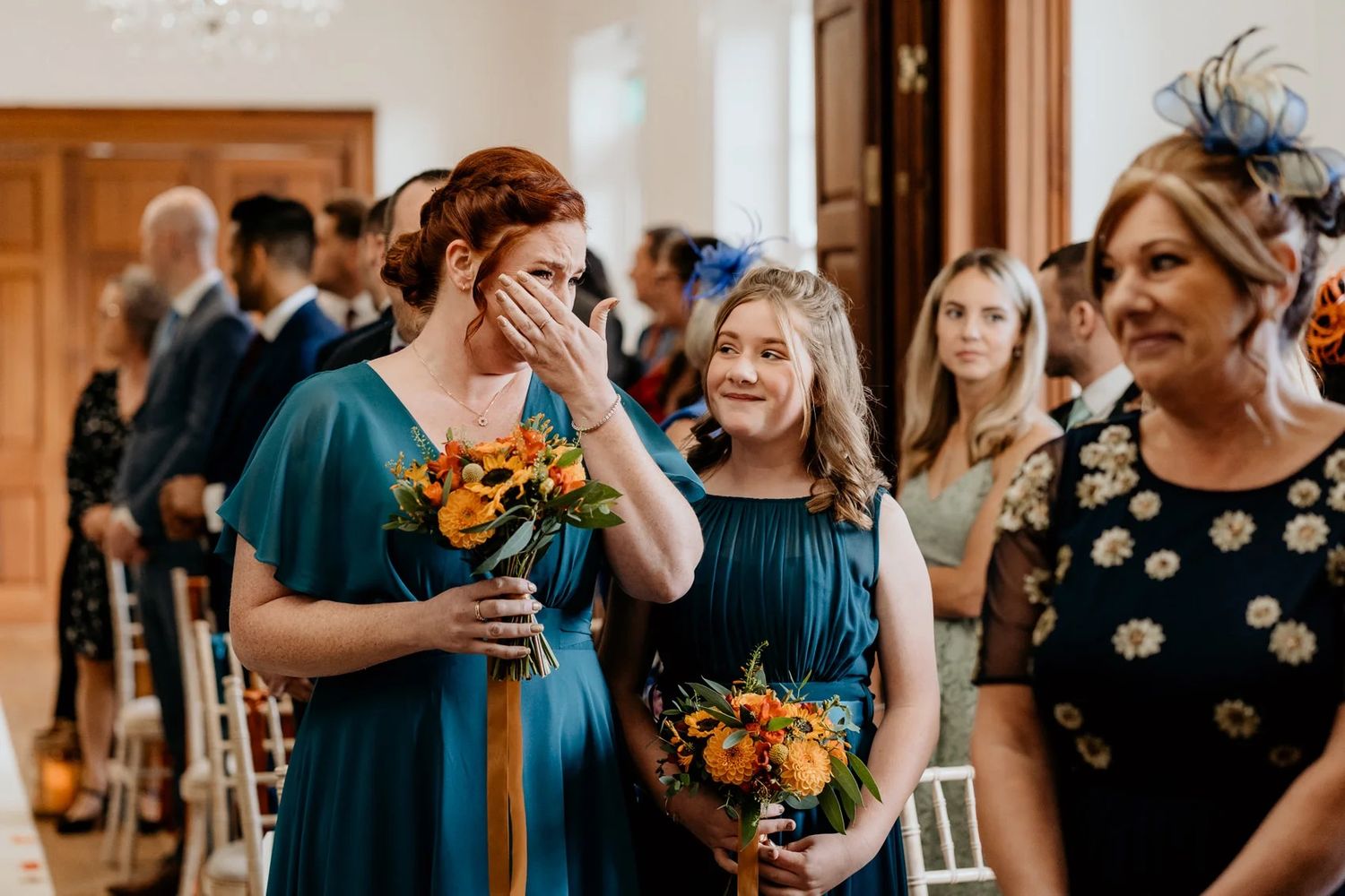 Celebration scene in indoor venue with navy and orange color theme featuring floral arrangements.