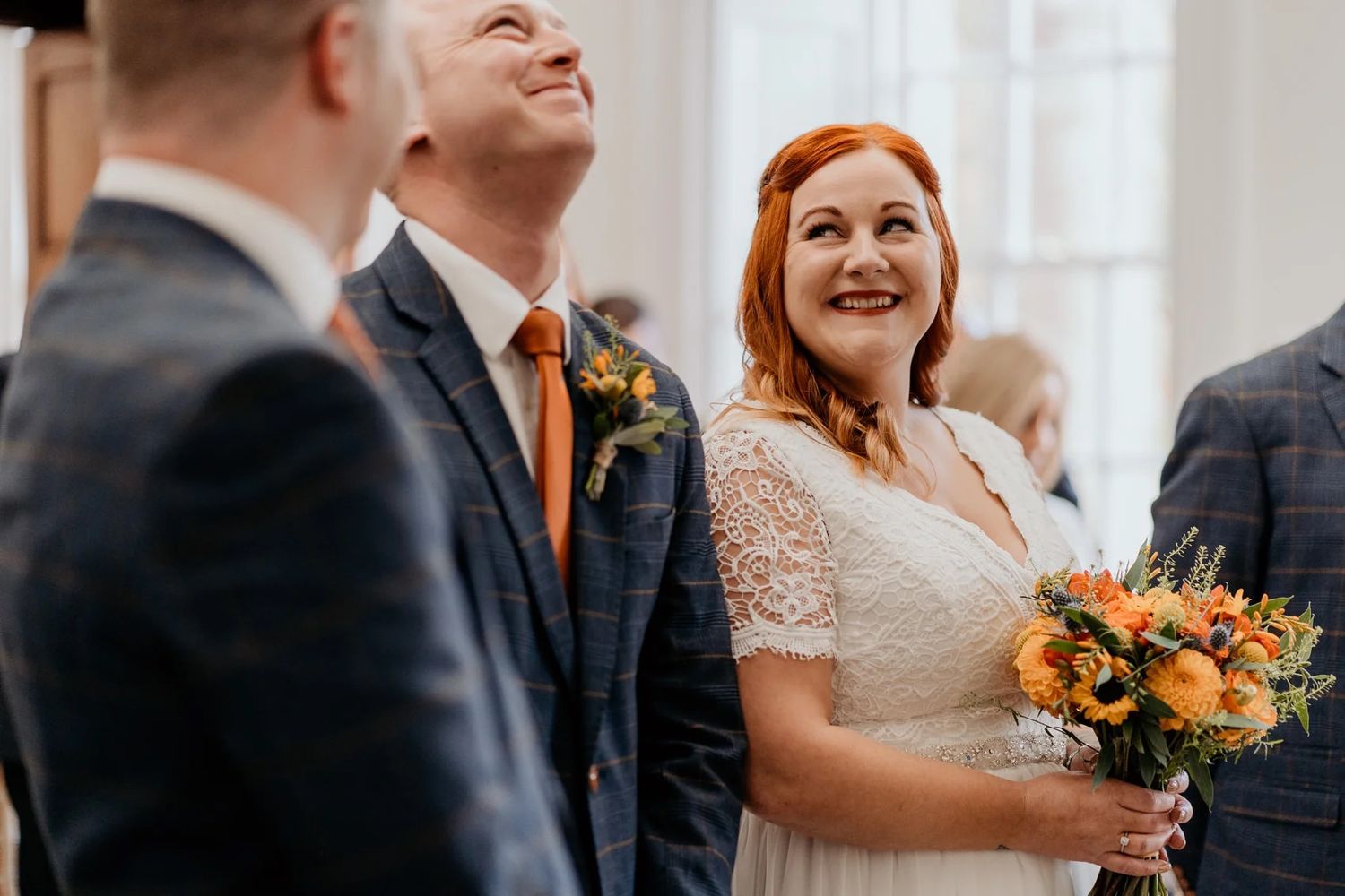 A joyful wedding moment captured with autumn-colored bouquet of sunflowers.
