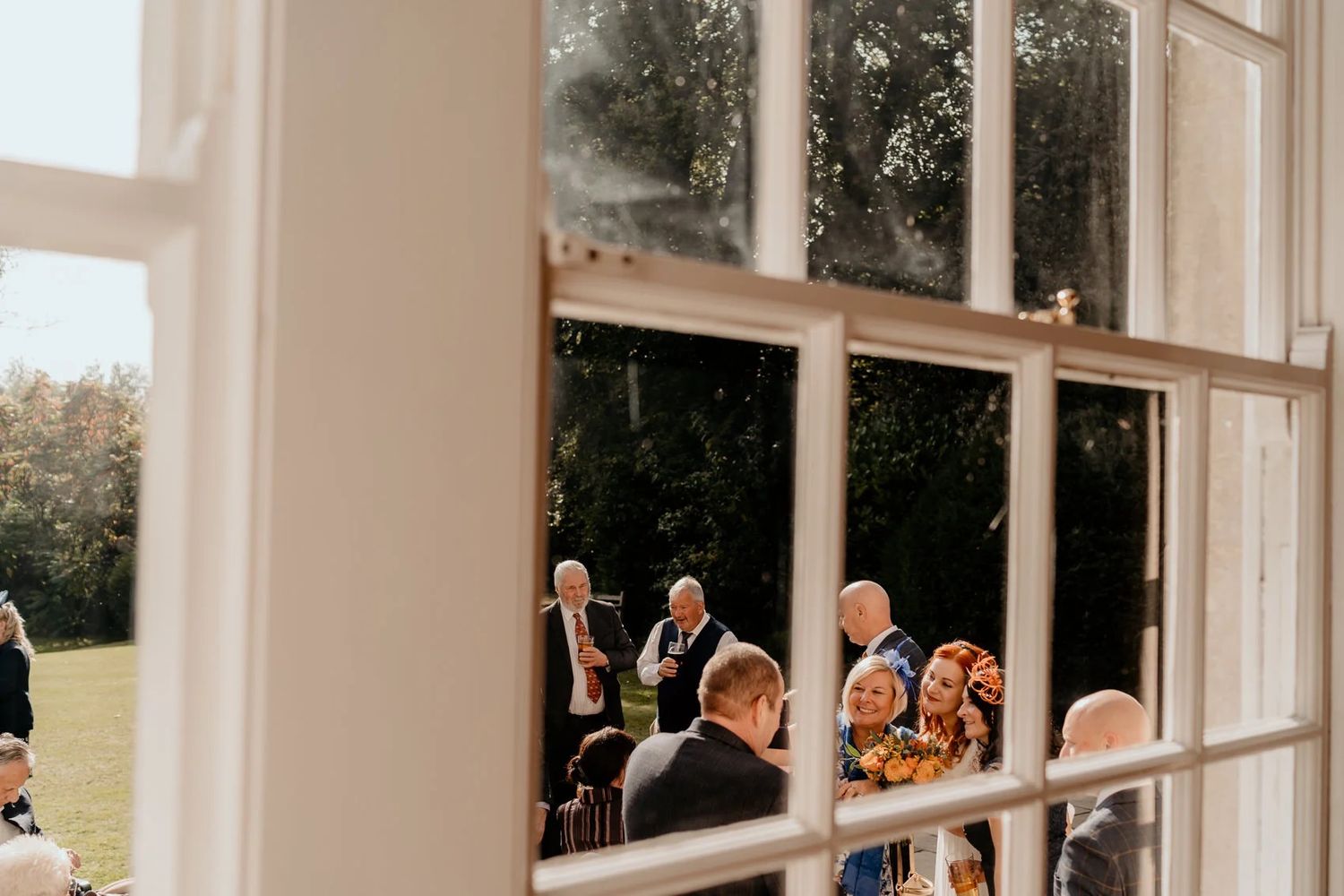Bright sunlit wedding venue with large windows and elegant white interior details.