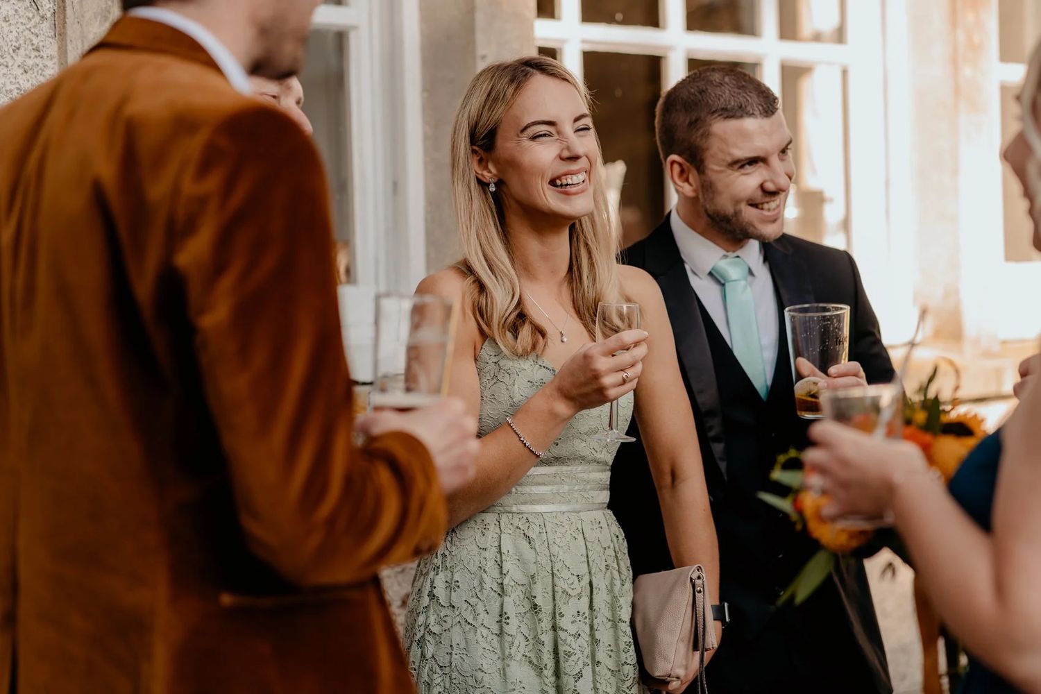 Wedding guests enjoy drinks and conversation at an elegant indoor reception venue.