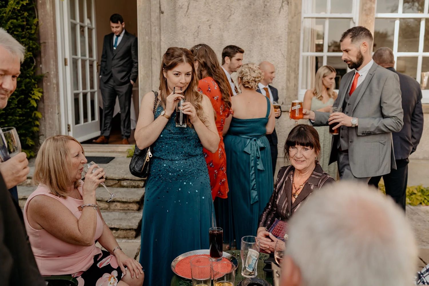 Wedding guests mingle and socialize during a celebration at a historic venue.