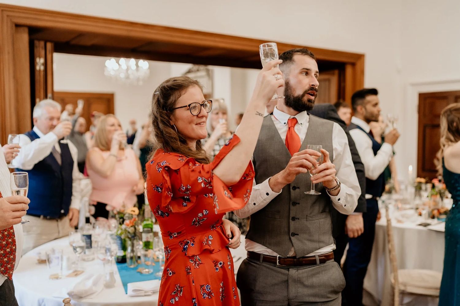Wedding reception celebration with guests dancing and socializing in a bright indoor venue.