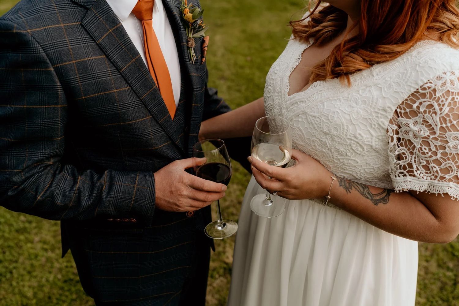 Close-up details of formal wedding attire including lace and suit jacket.