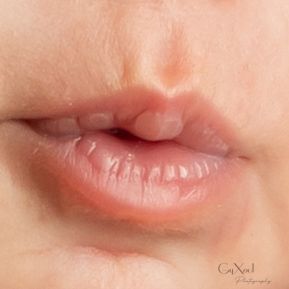 Close-up of natural, glossy lips with soft pink tones, showcasing a professional beauty photography style.
