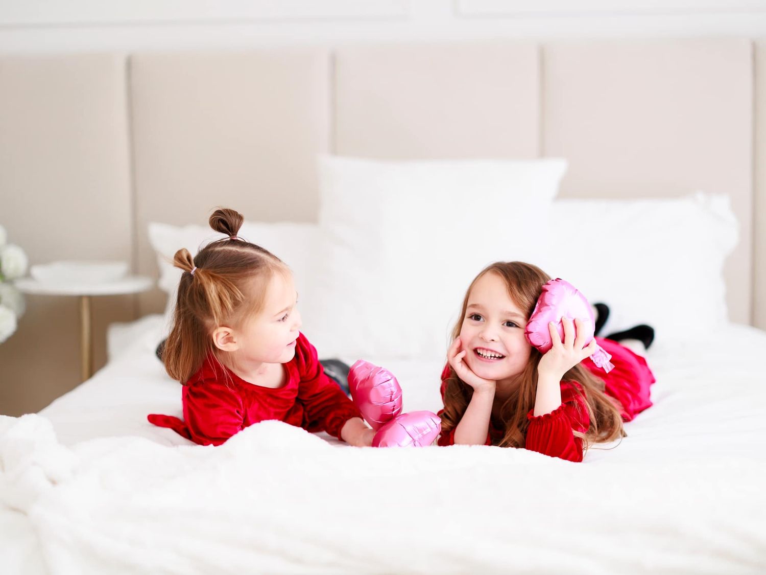 Children’s portrait of two sisters playing on a bed during a Toronto family photo session