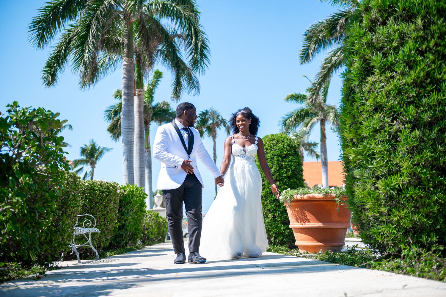 This bride and groom are walking together unscathed by the moment. Calmly directed by Palm Beach wedding photographers.