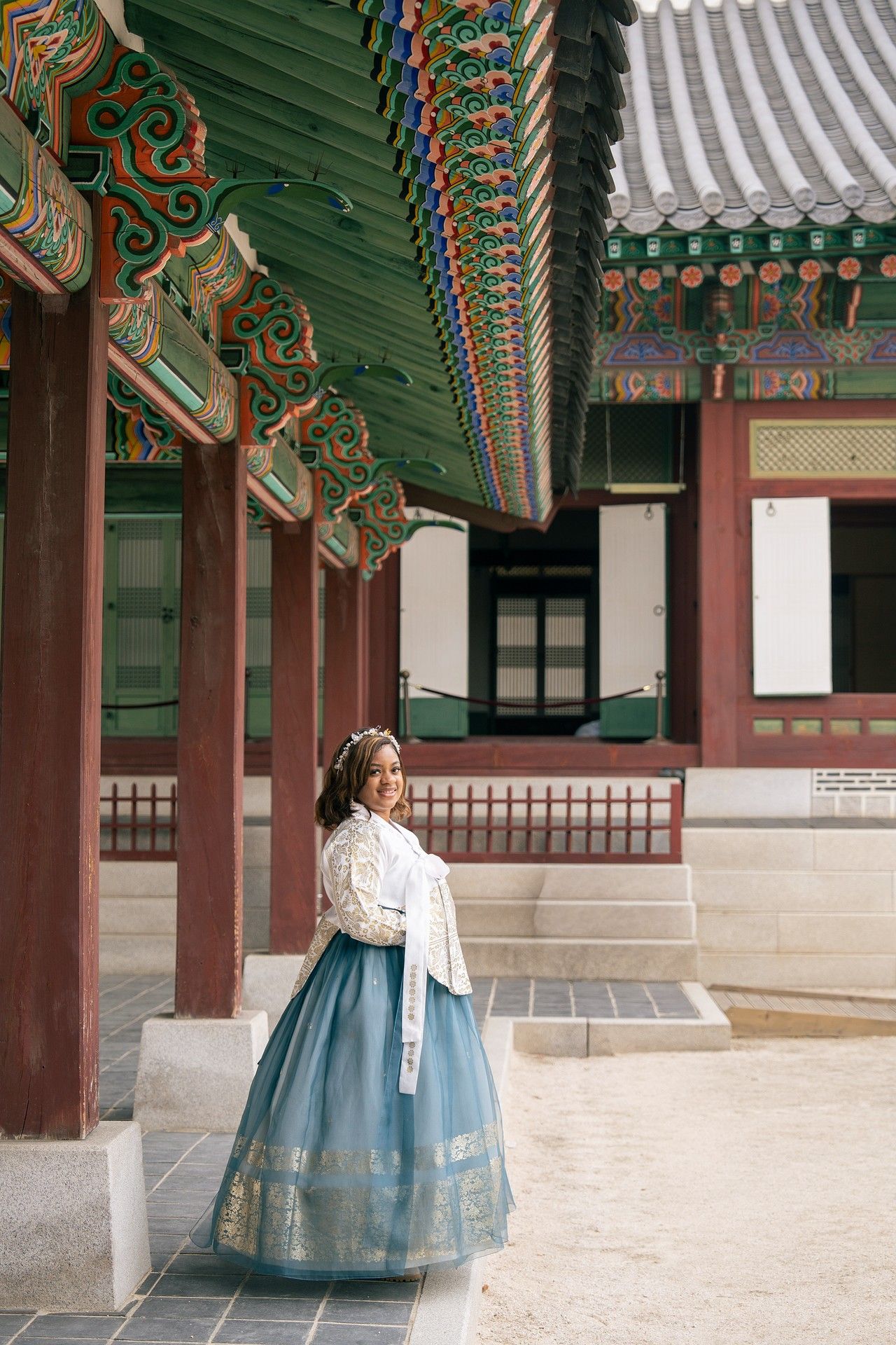Woman in traditional Korean hanbok dress posing at Gyeongbokgung Palace in Seoul, South Korea.