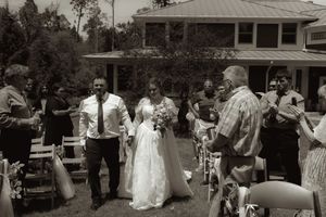 Bride and groom walking back down the aisle after outdoor wedding ceremony in black and white.