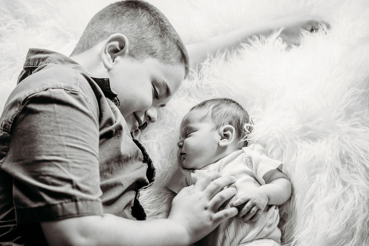 sibling laying beside newborn during in-home session