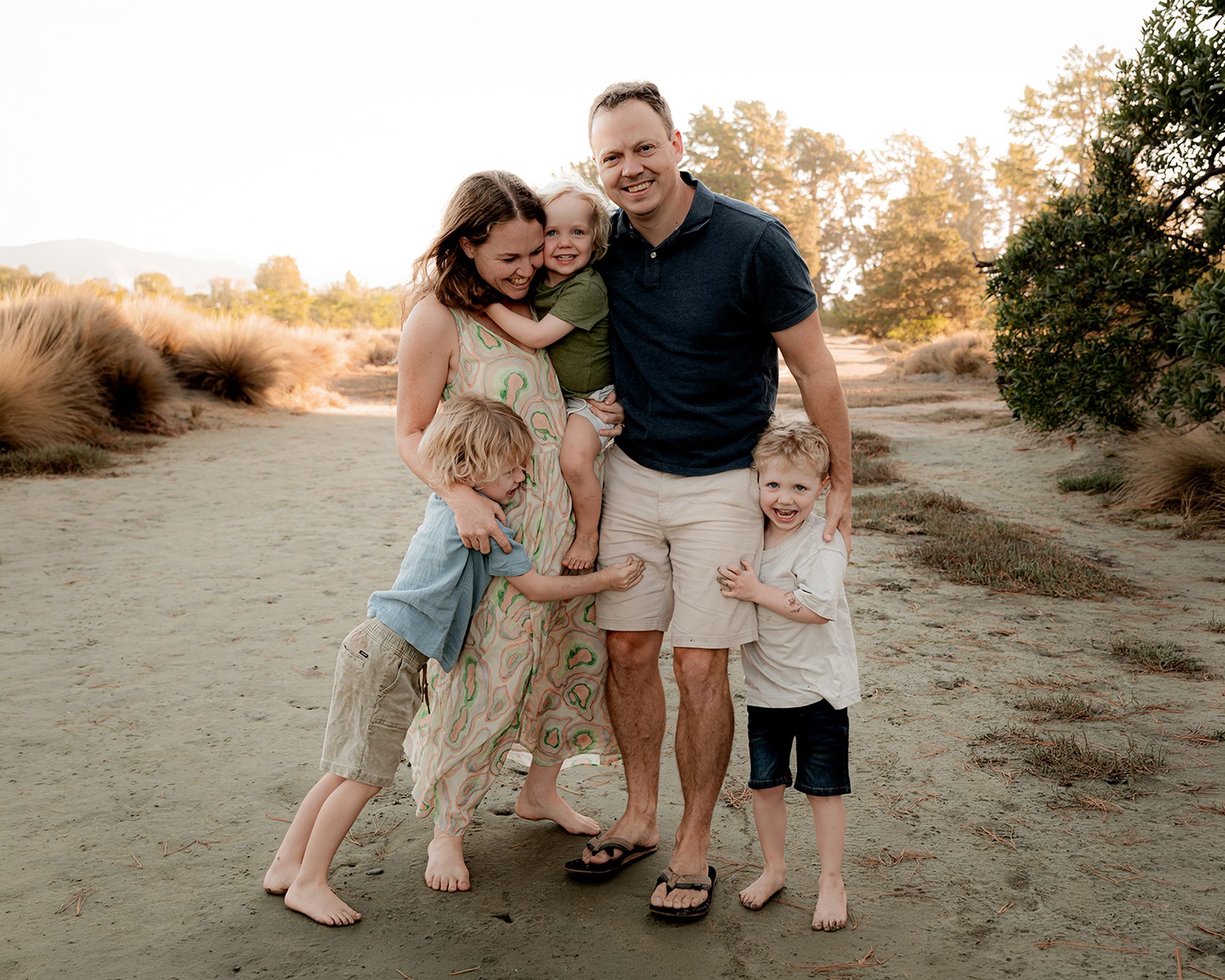 Child laughing while being cuddled by parents