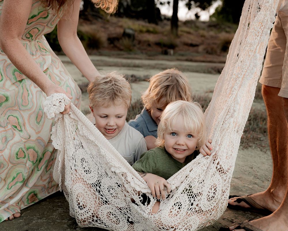 kids playing in a crochet blanket during family photos