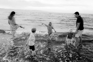 Family splashing in the water together during outdoor photography session