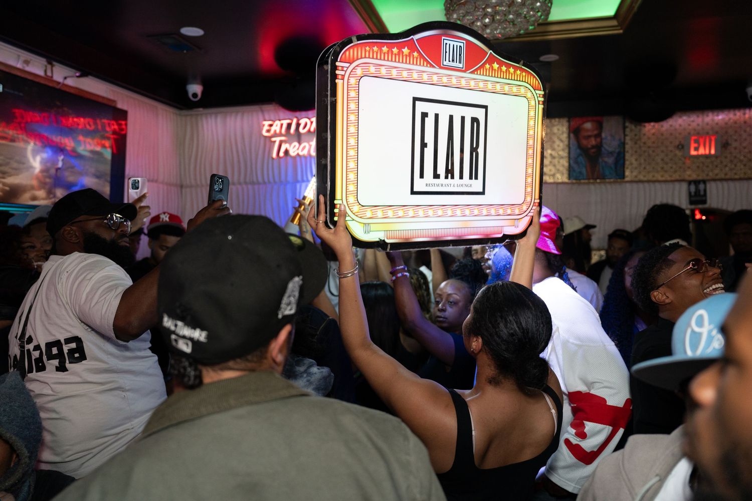 Crowd of people partying at Flair nightclub, with illuminated Flair sign held above the dance floor.