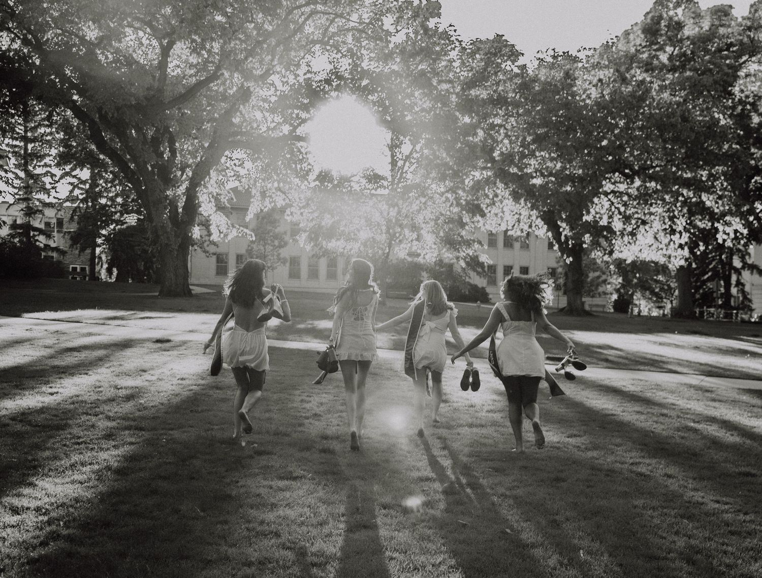 Friend group runs away together graduation photography for CSU (Colorado State University) graduation photos in Fort Collins, Colorado