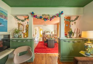 Green ceiling living space decorated with Christmas garland, ornaments, and holiday decor.