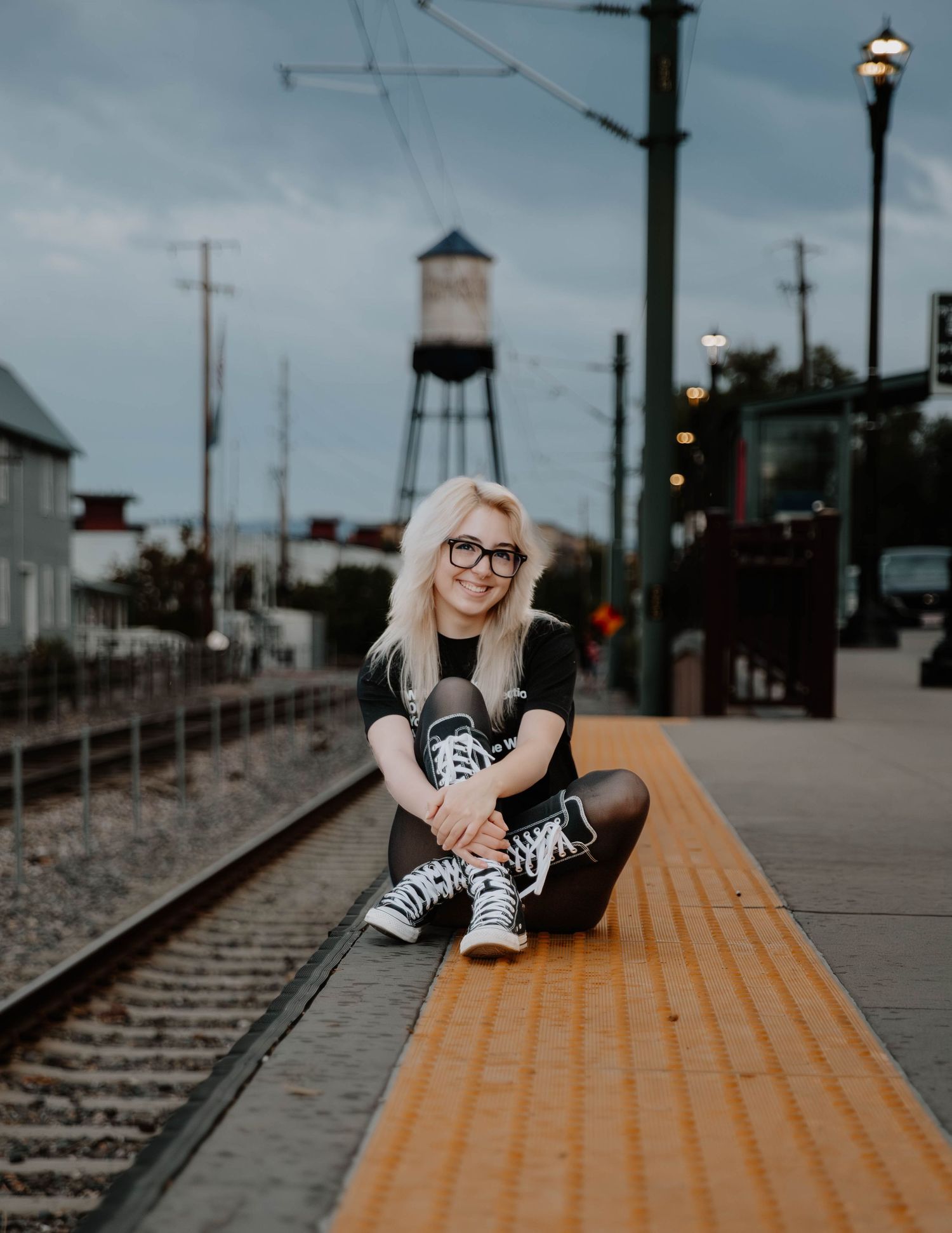 Girl sits down and poses for senior photos, cinematic photos, and portraits in Arvada, Colorado outside and in nature photo