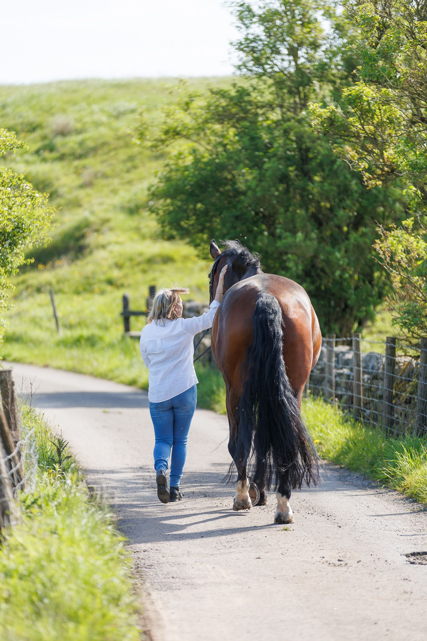 A series of photos showing a person in a white polka dot shirt with a black horse in a golden autumn field.