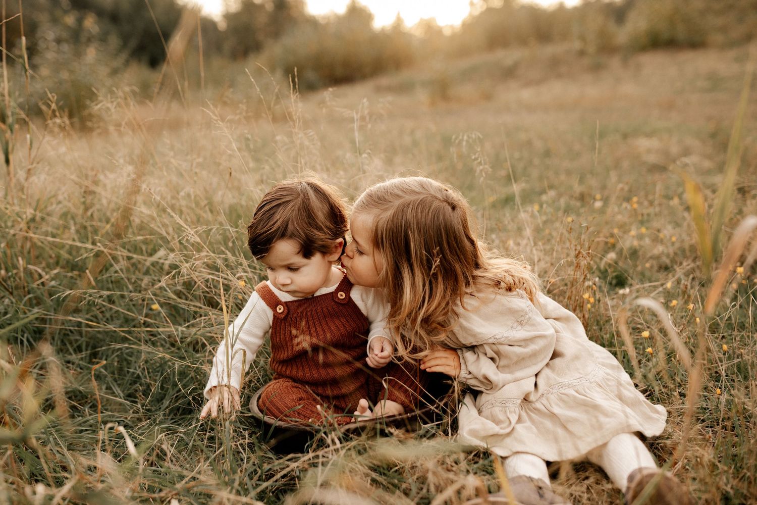 Romantic outdoor photoshoot in a golden field at sunset with warm autumn tones.