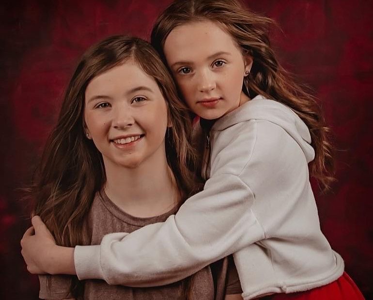 Two people embrace and share joyful moments together against a deep red background in a photo series.